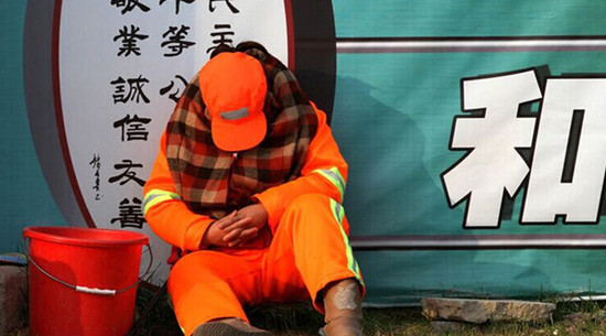 每天必須12小時在路面值守以時刻保持路面的清潔，環(huán)衛(wèi)工人只能蜷縮在馬路啃饅頭、打瞌睡
