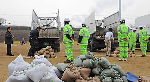 韓國環(huán)衛(wèi)工人應(yīng)聘者在考試現(xiàn)場接受多項體能考試，包括100米跑、仰臥起坐、背沙袋和50米跑等